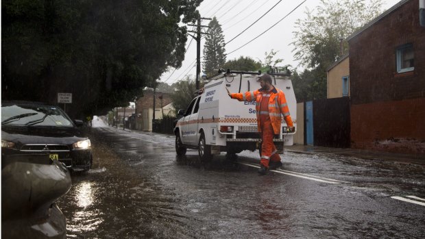 A State Emergency Service volunteer blocks off a flooded street in St Peters on June 5.