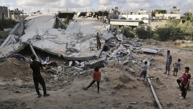 Palestinians inspect the rubble of a destroyed building after it was hit by an Israeli airstrike in Beit Lahiya, northern Gaza Strip.