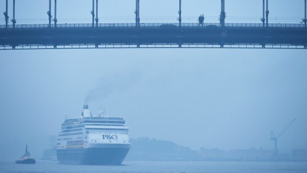 A cruise ship travels through the harbour on the city's third smoky morning. 
