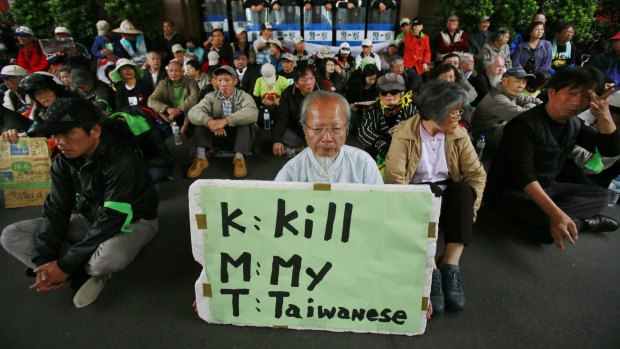 Protesters against Taiwan's trade pact with China stage a sit-in outside parliament with a sign denouncing the ruling Kuomintang in 2014.