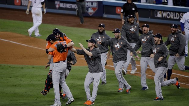 The Astros pour from the dugout to celebrate their World Series win.