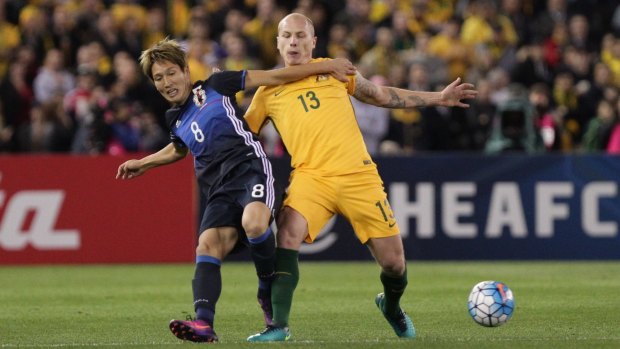 Rematch: Aaron Mooy and Japan's Genki Haraguchi battle hard for the ball during last year's World Cup qualifier in Melbourne.