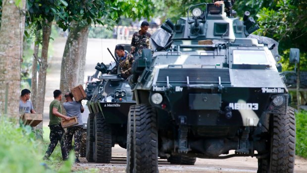 Troops load ammunition and supplies as a convoy of APCs head to the site three days after Muslim militants lay siege in Marawi city.