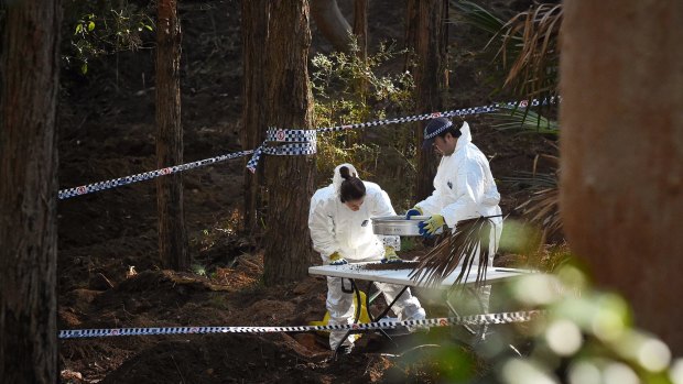 NSW forensic services officers sift through soil at the crime scene.