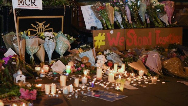Candles, flowers and cards placed in honour of the victims at a vigil in Manchester. 