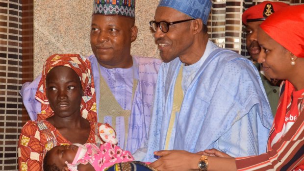 Nigeria President Muhammadu Buhari, third right, greets Amina Ali, left, the rescued Chibok school girl, and her four-month-old baby at the Presidential palace on Thursday. 