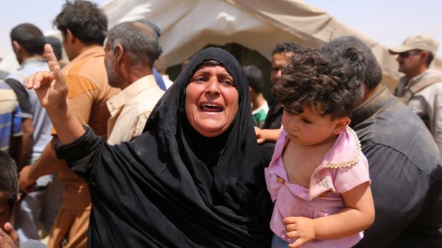 A woman who fled Ramadi holds a child  in a camp in Amiriyat al-Fallujah, west of Baghdad.