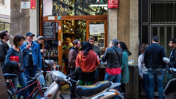 Bodega patrons spill out into the street in Barcelona, in Spain.