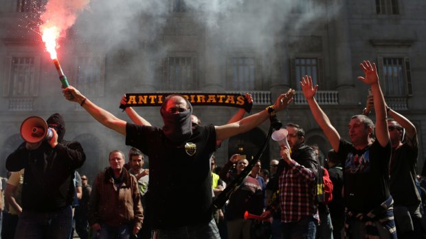 Protesters burn flares during a taxi strike in Barcelona, Spain, in March.