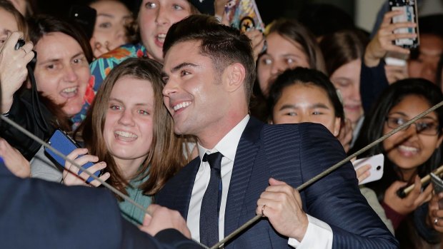 Zac Efron is caught in the crossfire of selfie sticks on the red carpet.