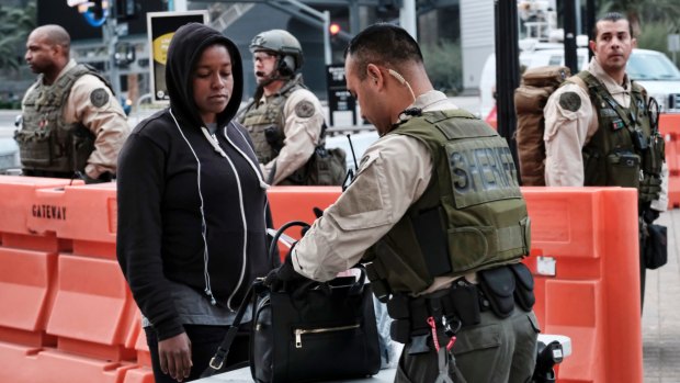 A morning commuter has her bag checked by a Los Angeles County Sheriff's deputy at the Universal City Red Line station in Los Angeles.