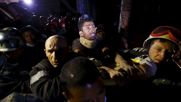 Rishi Khanal looks around at the surroundings as he is pulled from the rubble of a building after four days trapped. 
