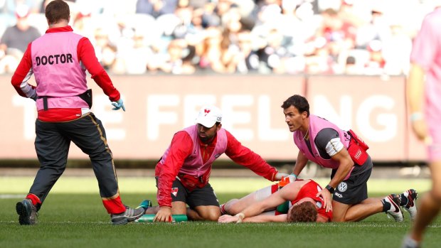 Gary Rohan of the Swans lies injured at the MCG after a collision with Blues defender Sam Rowe. 