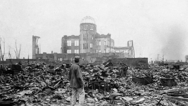 An Allied correspondent stands in the rubble of Hiroshima a month after the first atomic bomb was dropped by the US. 