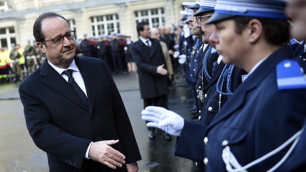 French President Francois Hollande shakes hands to police officers at the Paris' police headquarters, one year after the attack targeting the French satirical newspaper Charlie Hebdo that left 12 dead.