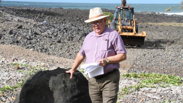 Kevin Lindeberg with the basalt boulder on Mon Repos Beach. Photo: Supplied
