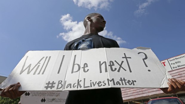 Niamke Ledbetter, of Oak Cliff, Texas, holds a sign at a Black Lives Matter protest in Dallas on Sunday.