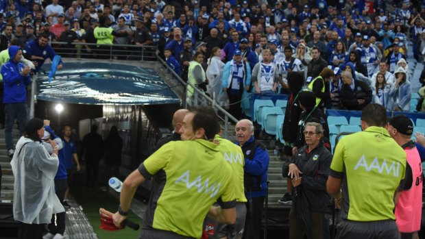 Dark day: a touch judge is hit by a water bottle after the South Sydney v Canterbury match.