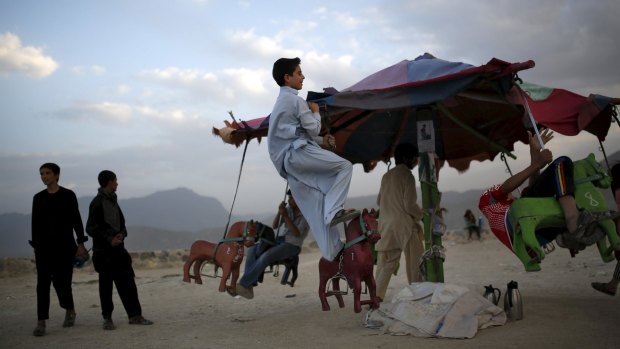 An Afghan boy plays on a merry-go-round on a hill top in Kabul earlier this month. Weary with decades of war and hoping for a return to normal life, many Afghans hope the Taliban and Afghanistan's government will make progress with peace talks. 