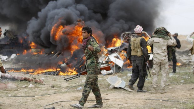 Shiite militia fighters at the scene of an IS suicide bombing on the southern edge of Tikrit.