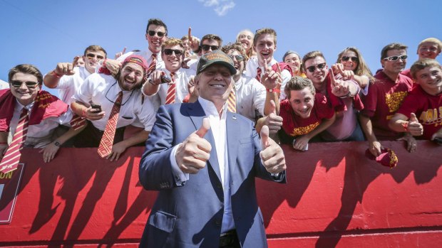 Republican presidential candidate Donald Trump poses for a photo with Iowa State football fans.