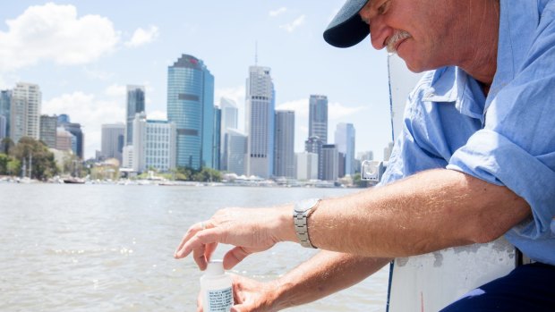 Healthy Waterways' Mark Davidson collects a sample on the Brisbane River.