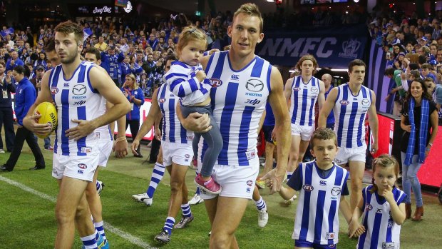 North Melbourne's Drew Petrie is acompanied by his children as he takes the field for his 300th game.