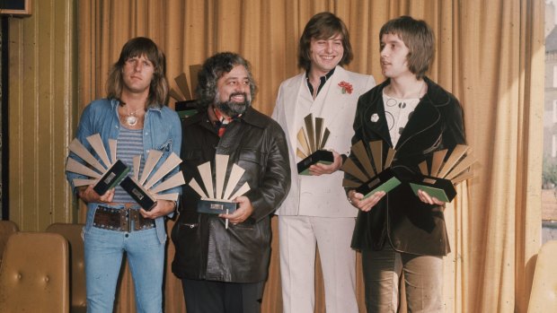 Emerson, Lake and Palmer receive awards for the world's most popular group as voted by readers of British music weekly <i>Melody Maker</i> in 1972. Left to right: keyboardist Keith Emerson, lead singer and bassist Greg Lake and drummer Carl Palmer. They are with American disc jockey and singer Wolfman Jack. 