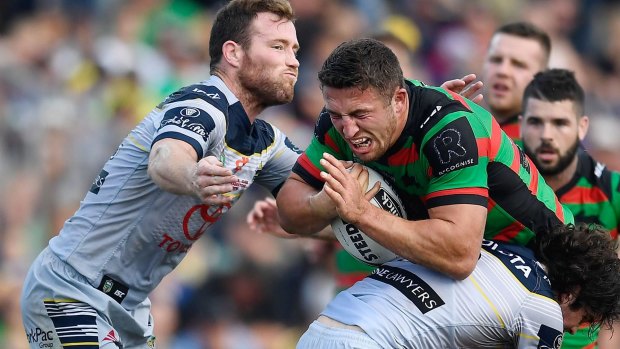 Sam Burgess of the Rabbitohs is tackled by Gavin Cooper and Jake Granville of the Cowboys.