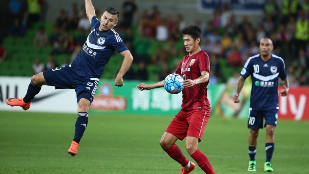 Kosta Barbarouses of Melbourne Victory is airborne as he challenges Hai Yu of Shanghai SIPG.