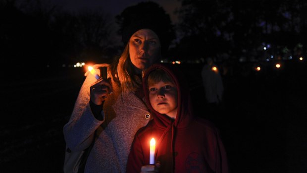 Evatt's Erin Regan and her son Seth Mulvey, 9, pay tribute to Ms Regan's sister Leanne, who died as a result of domestic violence, at a candlelight vigil on Wednesday.
