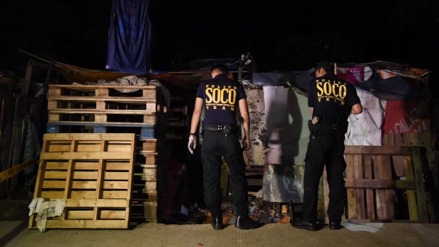 Philippine police at a crime scene in Quezon City after a man was shot execution style by six masked men.