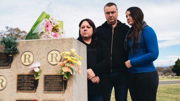 Mark Knowles, with his wife Tracy and daughter Ashley, visit the plaques at Queanbyean Lawn Cemetery for his mother, Carol Saxton, and his sister, Patricia Riggs.