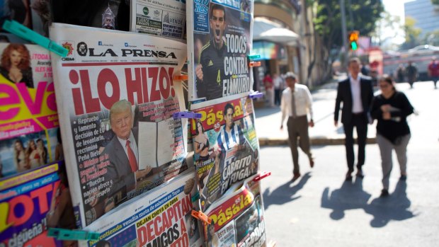 A front-page newspaper headline in Mexico City reads "He did it!" over a picture of US President Donald Trump holding up signed documents as he took action to jumpstart construction on a promised border wall.