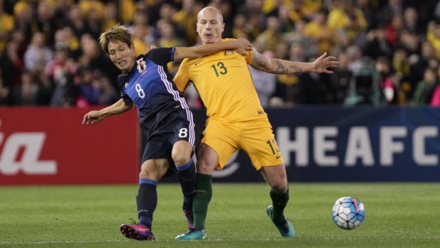 Rematch: Aaron Mooy and Japan's Genki Haraguchi battle hard for the ball during last year's World Cup qualifier in Melbourne.