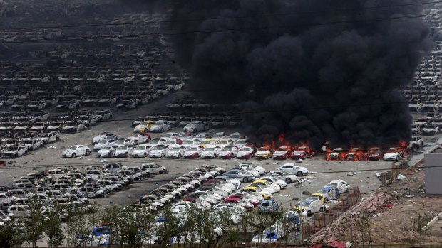 Smoke rises as damaged vehicles are seen burning near the site of Wednesday night's explosions.