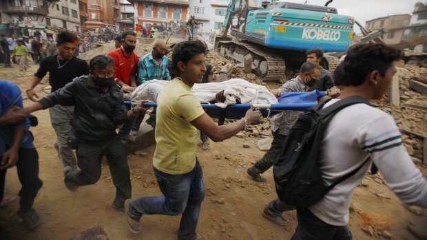 Volunteers carry the body of an earthquake victim on a stretcher after buildings collapsed in in Kathmandu, Nepal.