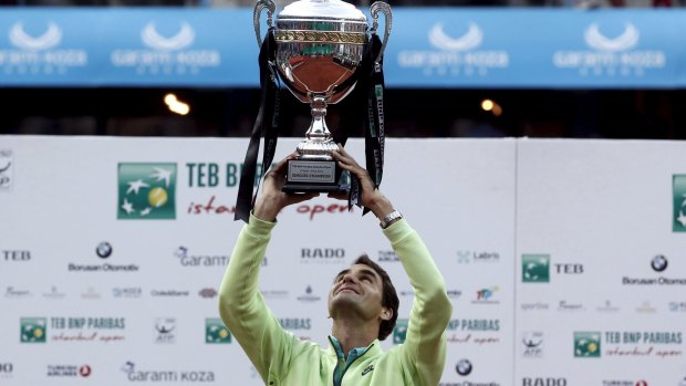 Roger Federer celebrates with the trophy.