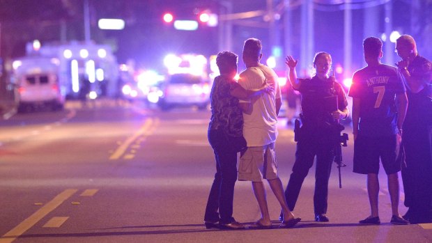 Orlando Police officers direct people away from a multiple shooting at the nightclub.  