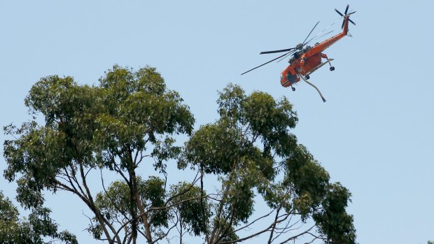 A water bombing helicopter flies over the Wandin fire ground on December 19.