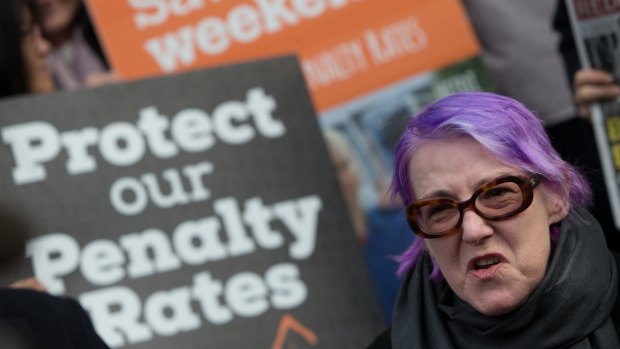 Hospitality and aged care worker Maire O'Connor protests on Collins Street, Melbourne.