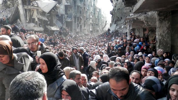 Residents of Yarmouk queuing for food in January 2014. Once home to 145,000 Palestinian refugees, the town has been taken over by Islamic State militants, forcing most residents and aid workers to leave and isolating those left behind.