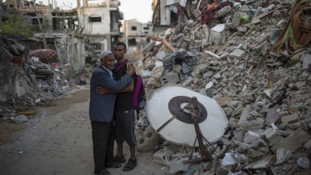 Palestinian Olympian Nader al-Masri and his father beside the rubble of their home in Beit Hanoun in Auust 2014.