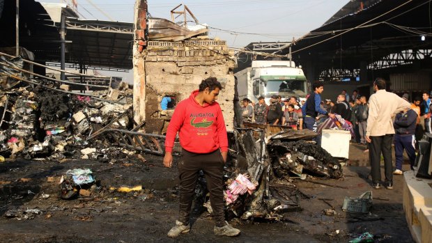 Citizens inspect the scene after a car bomb explosion at a crowded outdoor market in Sadr City.