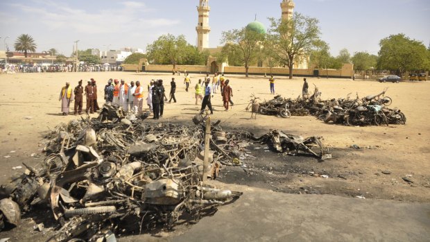 People inspect the site of a bomb explosion at the central mosque, in Kano.