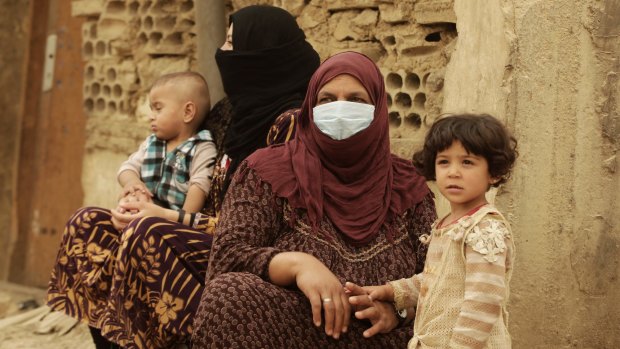 Syrian refugees cover their faces  during a sandstorm in a refugee camp in Lebanon.