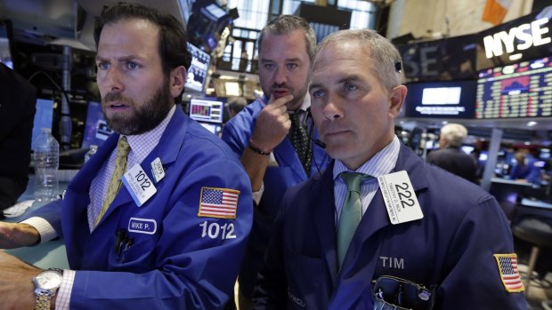 Volatile markets ... Specialist Michael Pistillo, left, works with traders Kevin Lodewick, centre, and Timothy Nick on the floor of the New York Stock Exchange on  Monday. 