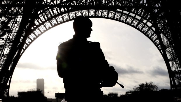 Armed military patrol the Eiffel Tower.