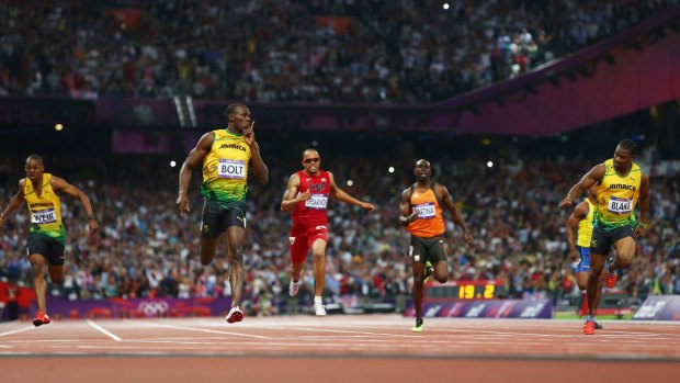 Silence please: Jamaica's Usain Bolt  crosses the finish line to win gold.