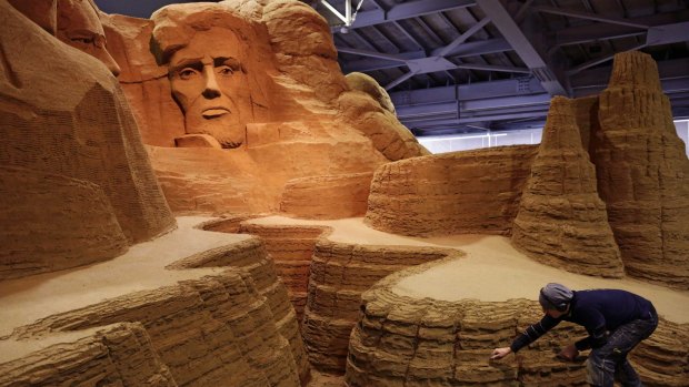 Leonardo Ugolini works on a sculpture inspired by Mount Rushmore's four presidents at the sand museum.